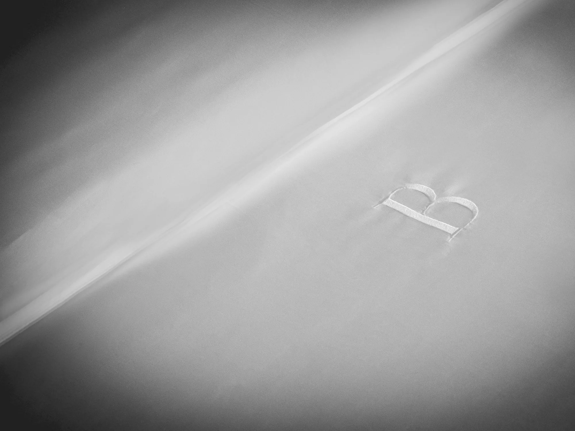 White embroidered B monogram on satin in close detail